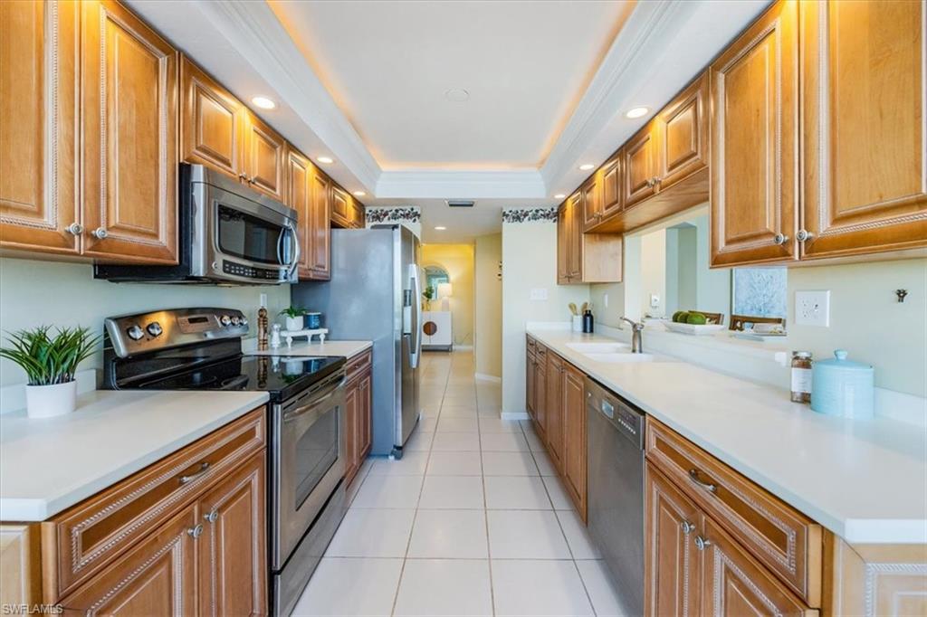 21 Bluebill Avenue, Unit B806 Naples, FL 34108 - Photo 10 of 22 a large kitchen with stainless steel appliances granite countertop a stove a sink and a microwave