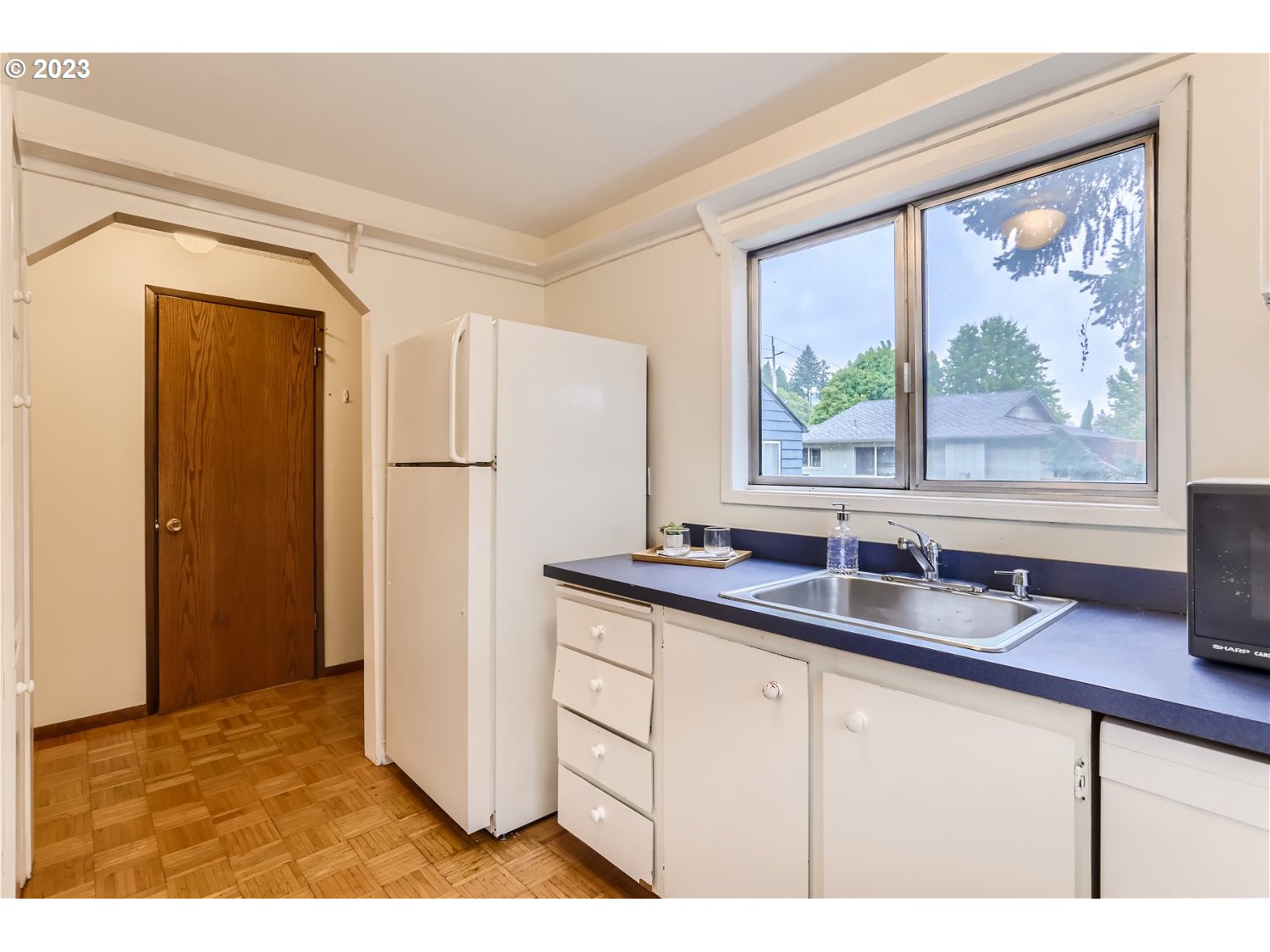 7410 South Virginia Avenue Portland, OR 97219 - Photo 6 of 27 a kitchen with a refrigerator a sink and a large window