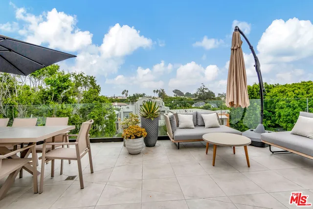 a view of a terrace with furniture and a garden