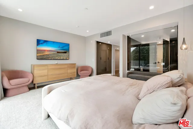 a bedroom with a bed and glass walk in closet