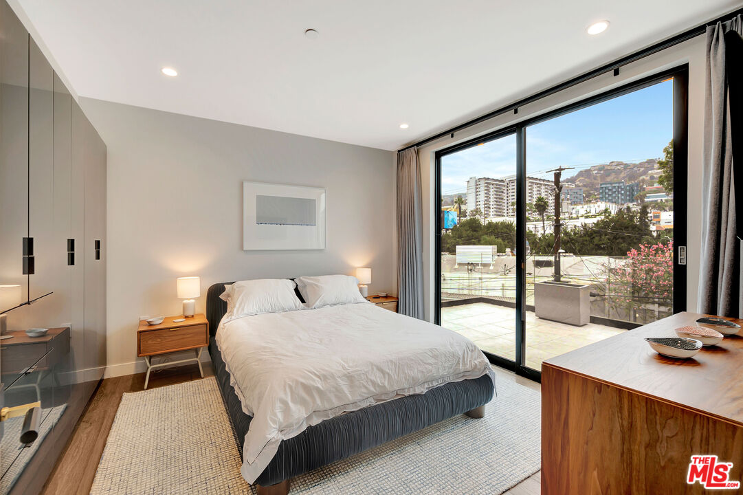 1017 North Croft Avenue, Unit PH1 Los Angeles, CA 90069 - Photo 20 of 34 a bedroom with a large bed and a large window