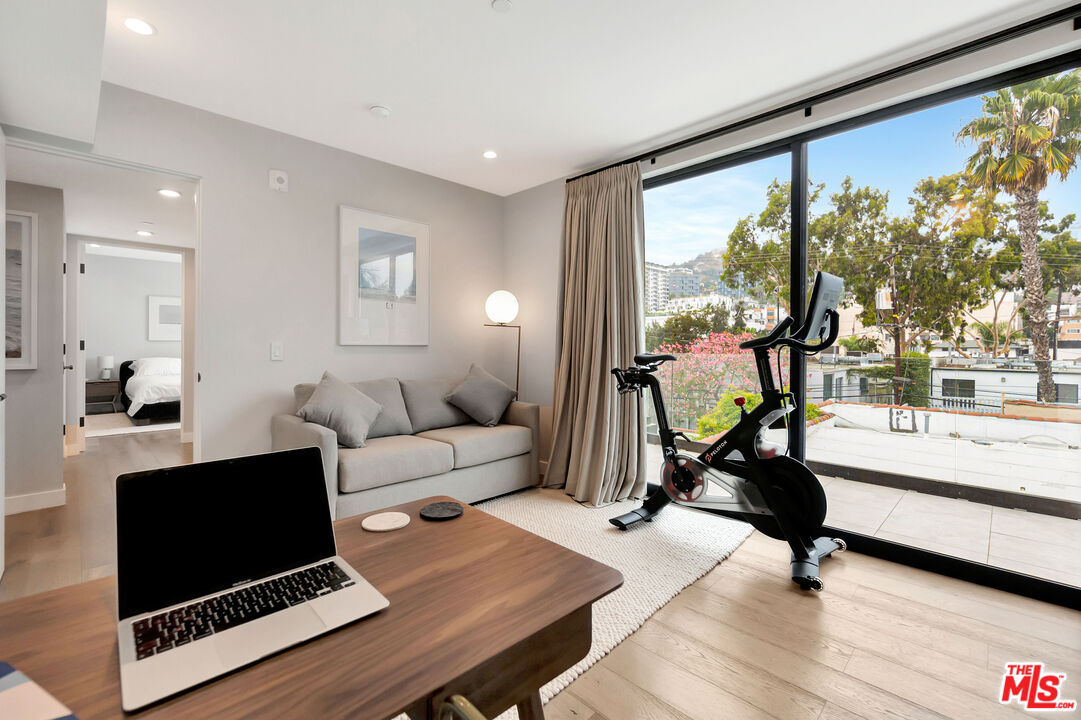 1017 North Croft Avenue, Unit PH1 Los Angeles, CA 90069 - Photo 24 of 34 a living room with furniture a flat screen tv and a floor to ceiling window