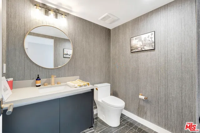 a bathroom with a sink mirror and toilet