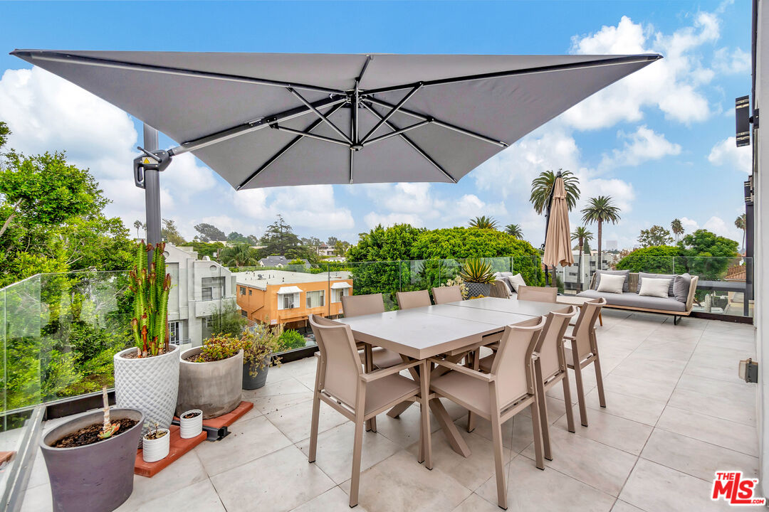 1017 North Croft Avenue, Unit PH1 Los Angeles, CA 90069 - Photo 27 of 34 a view of a patio with table and chairs under an umbrella