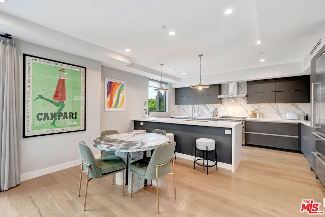 1017 North Croft Avenue, Unit PH1 Los Angeles, CA 90069 - Photo 8 of 34 a kitchen with stainless steel appliances granite countertop a refrigerator a sink a stove a dining table and chairs