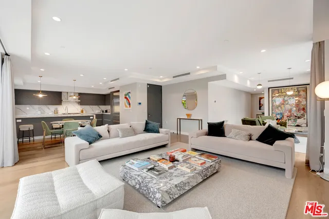 a living room with furniture kitchen view and a table