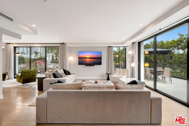 a living room with furniture and large windows