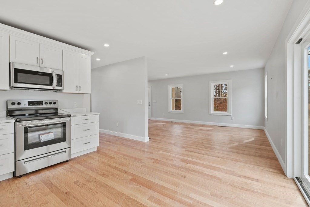 180 Barker Road East Wareham, MA 02538 - Photo 26 of 29 a kitchen with granite countertop a stove top oven a sink and a microwave