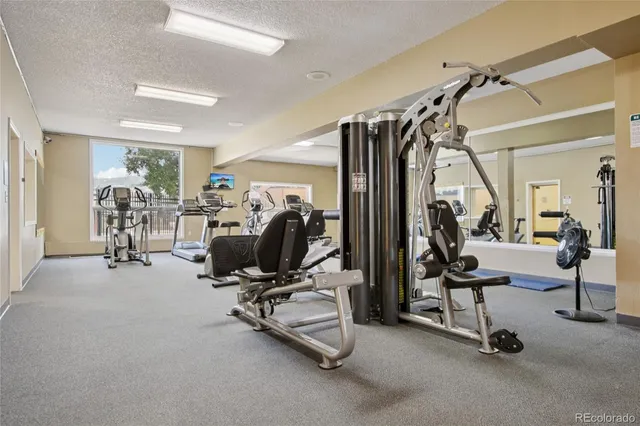 a room with gym equipment and large mirror