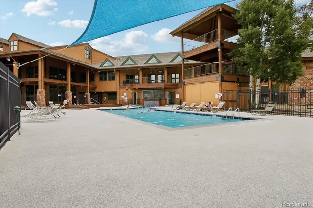 a swimming pool with outdoor seating and barbeque oven