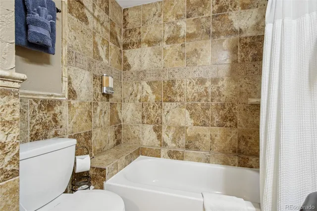 a bathroom with a sink a toilet a mirror and bathtub