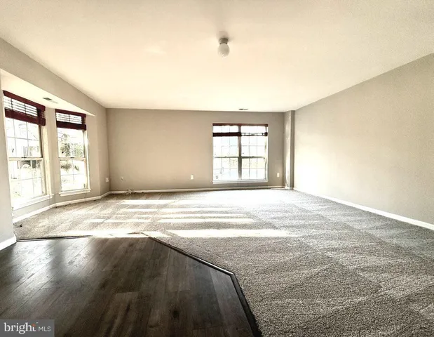 an empty room with windows and closet