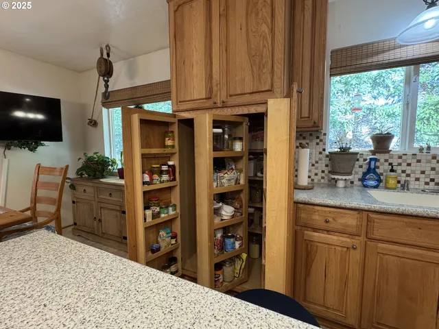 a kitchen with stainless steel appliances kitchen island granite countertop a refrigerator and cabinets