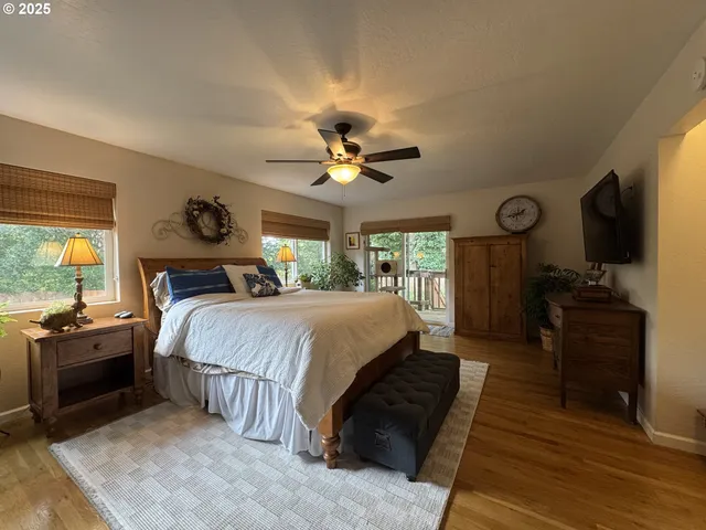 a spacious bedroom with a bed a couch and a chandelier