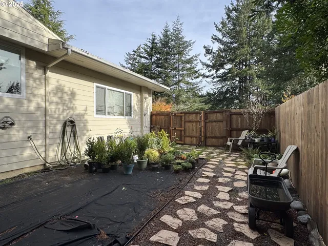 a view of a house with a yard and wooden wall