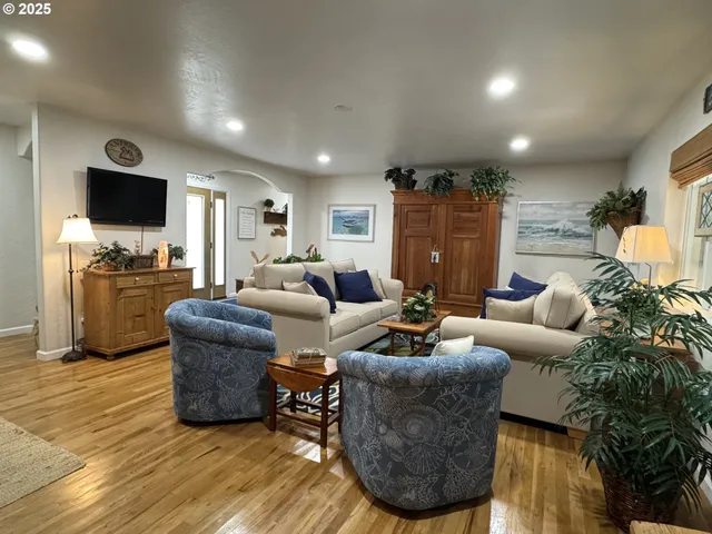 a living room with furniture a flat screen tv and kitchen view