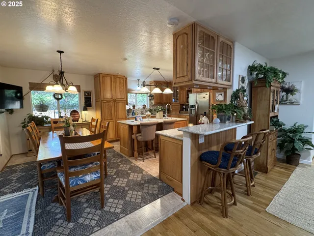 a living room with stainless steel appliances kitchen island granite countertop furniture a rug kitchen view and a chandelier
