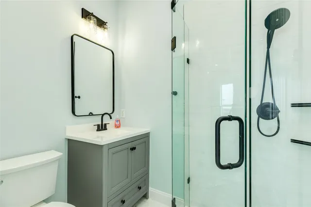 a bathroom with a sink vanity mirror and toilet