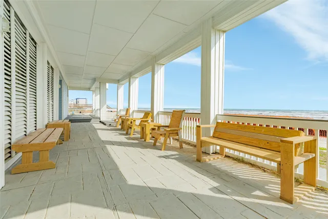 a living room with furniture stove and large windows