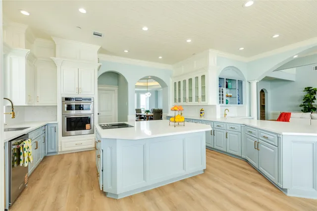 a large kitchen with stainless steel appliances lots of counter space and wooden floor