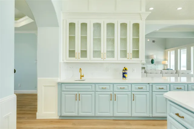 a kitchen with white cabinets and sink