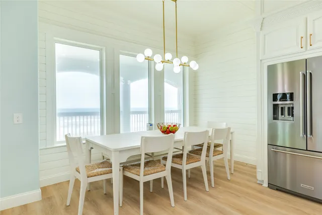 a dining room with furniture a chandelier and wooden floor
