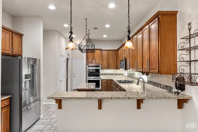 a kitchen with stainless steel appliances granite countertop a stove microwave and cabinets
