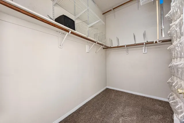 a view of an empty room with a chandelier fan