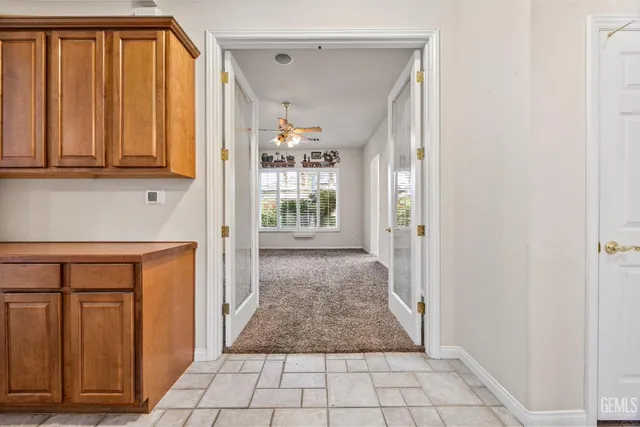 a view of a kitchen with white cabinets and refrigerator