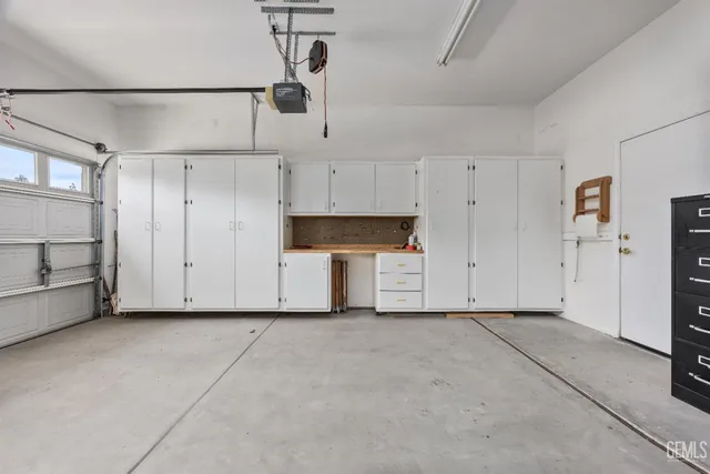 a view of swimming pool that has lawn chairs with plants and trees