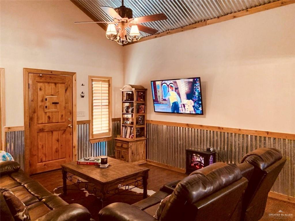 2938 Highway 83 Roma, TX 78584 - Photo 4 of 23 Living room with wainscoting, a ceiling fan, and a towering ceiling