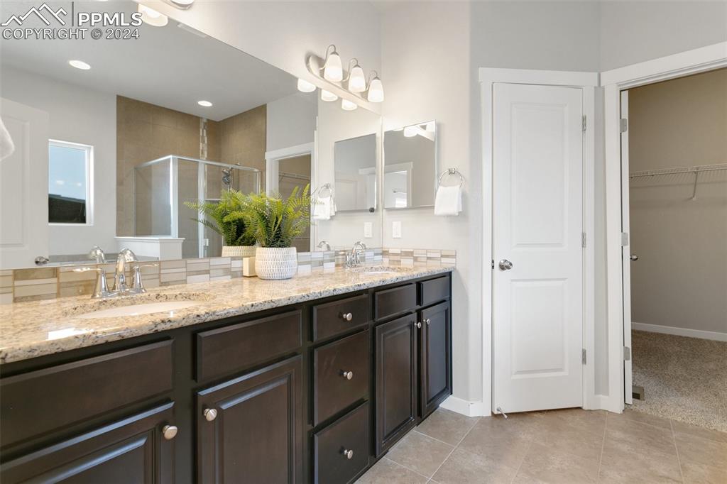 10110 Henman Terrace Peyton, CO 80831 - Photo 16 of 36 a bathroom with a granite countertop sink double and mirror