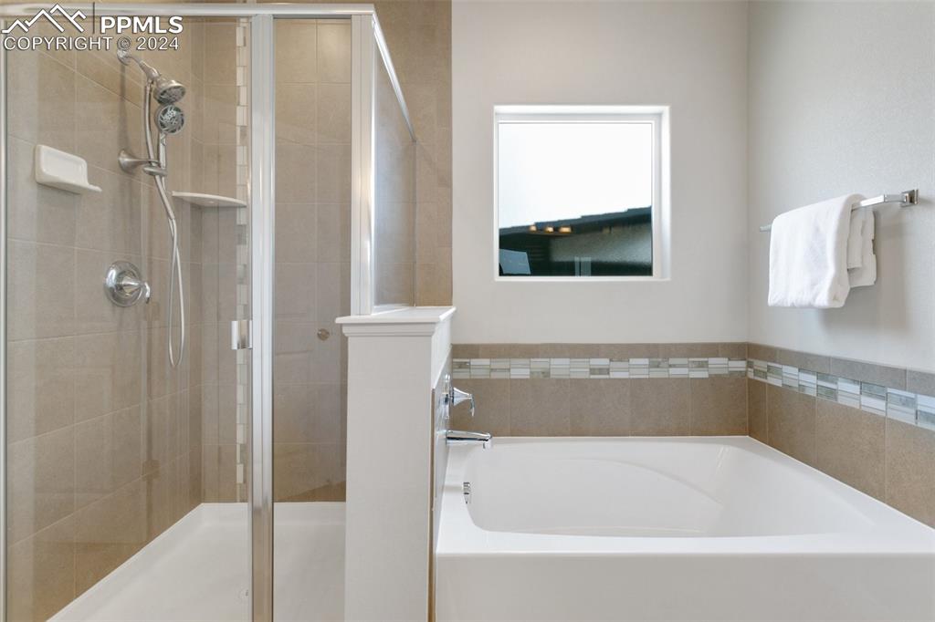 10110 Henman Terrace Peyton, CO 80831 - Photo 17 of 36 a bathroom with a tub shower and sink