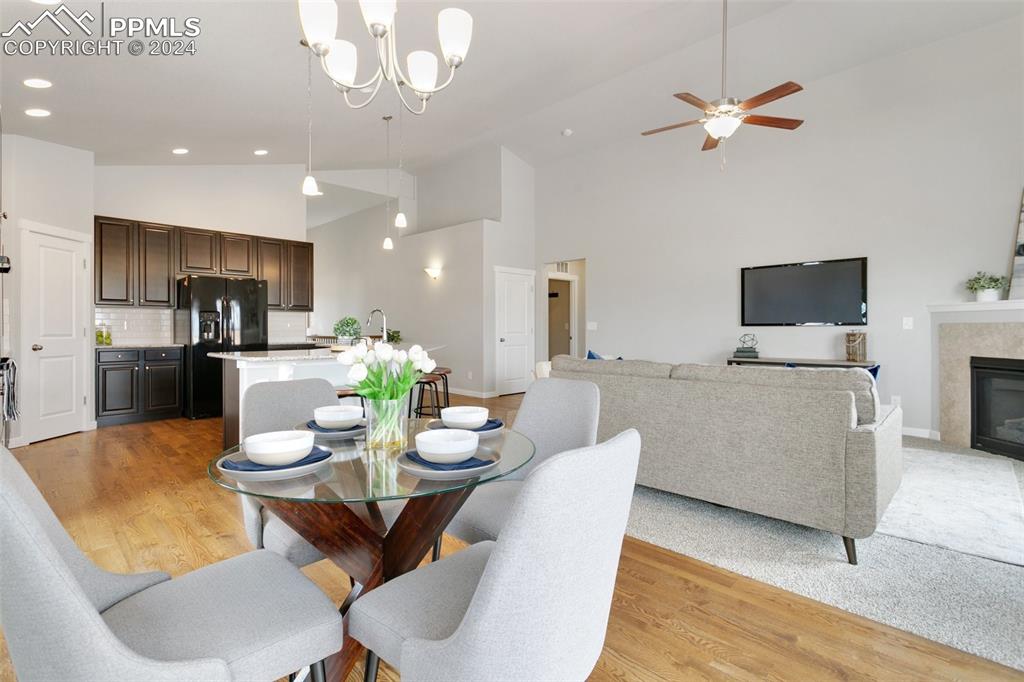 10110 Henman Terrace Peyton, CO 80831 - Photo 8 of 36 a view of a dining room with furniture a kitchen a chandelier fan and wooden floor