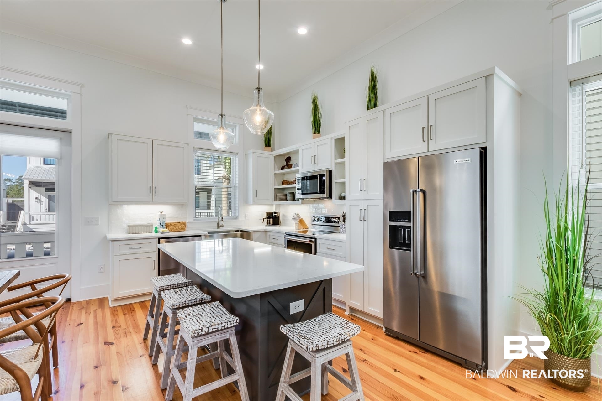 2494 Saltgrass Way Orange Beach, AL 36561 - Photo 6 of 37 Kitchen featuring white cabinetry, decorative light fixtures, a center island, appliances with stainless steel finishes, and a kitchen breakfast bar