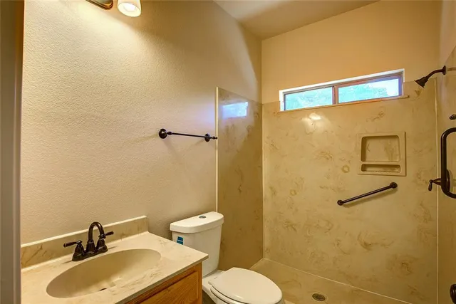 a bathroom with a sink toilet and shower