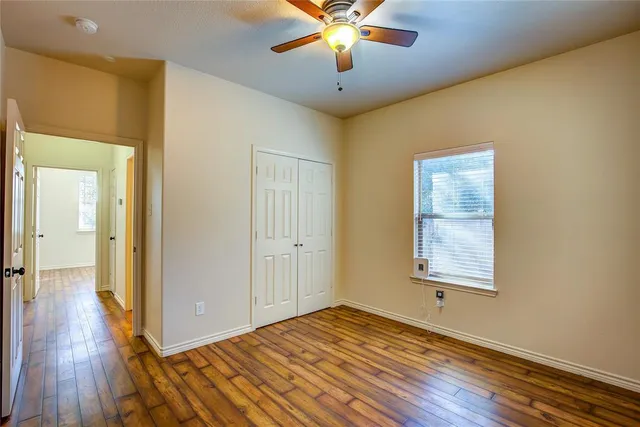 a view of a livingroom with wooden floor and a ceiling fan