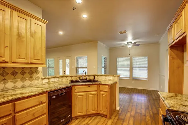 a view of a kitchen with kitchen island wooden floors stainless steel appliances