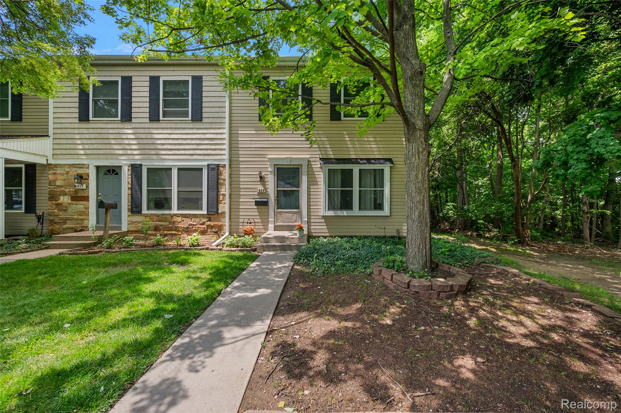 930 Little Hill Court Rochester, MI 48307 - Photo 2 of 38 Townhome exterior featuring light-colored siding and a stone facade