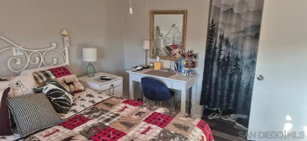 a bed that has a blanket on it and next to a window