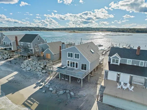 a kitchen with granite countertop stainless steel appliances a table chairs sink refrigerator and microwave