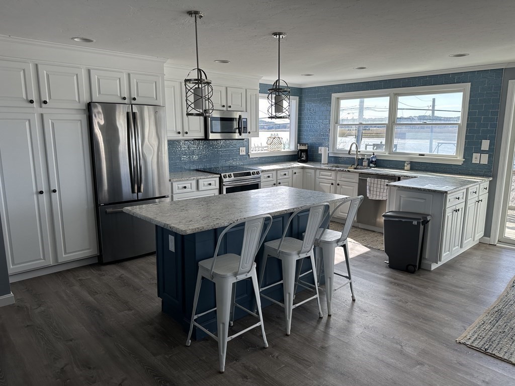 230 Central Avenue Scituate, MA 02050 - Photo 9 of 34 a kitchen with granite countertop stainless steel appliances a table chairs sink refrigerator and microwave