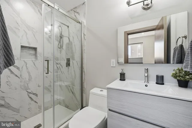 a bathroom with a sink a toilet and shower