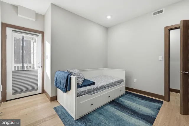 a living room with a bed and dresser