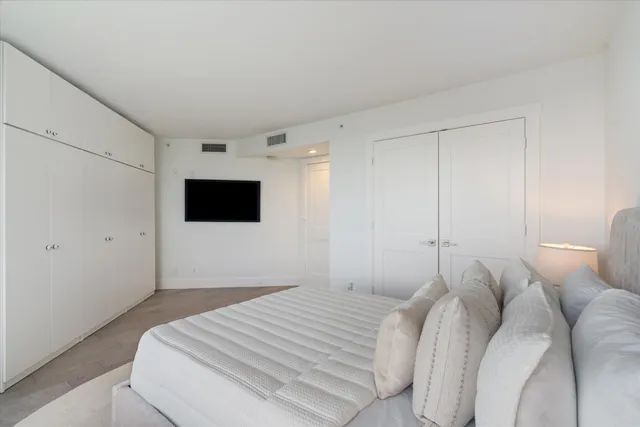 a bedroom with a bed and a flat screen tv