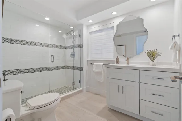 a bathroom with a sink a toilet and shower