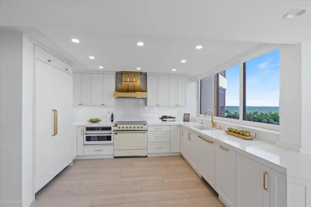 a large white kitchen with a large window