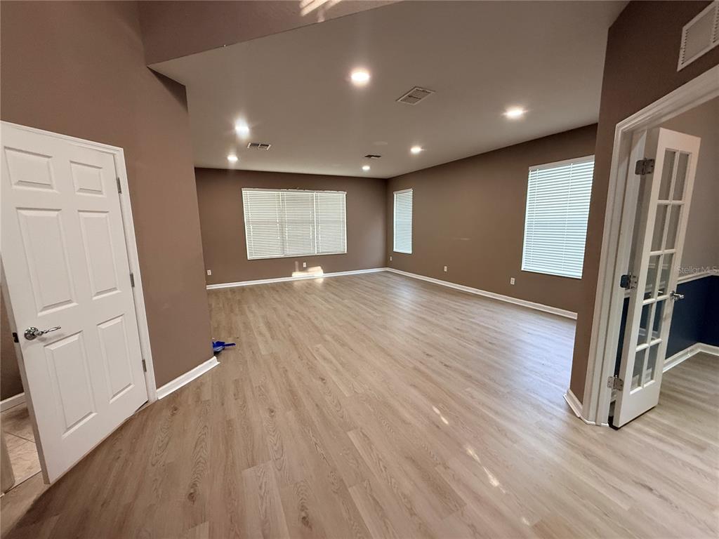 4199 Southwest 46th Court Ocala, FL 34474 - Photo 12 of 50 an empty room with wooden floor and a refrigerator