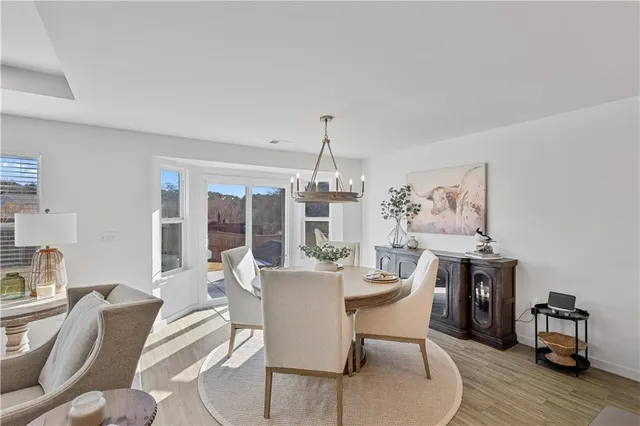 a dining room with furniture a chandelier and wooden floor