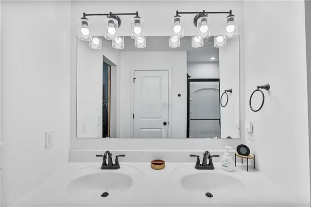 a bathroom with a glass shower door and a mirror